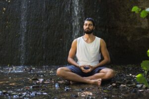 hombre meditando junto a una cascada